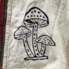 Embroidered mushrooms on colorful fabric.